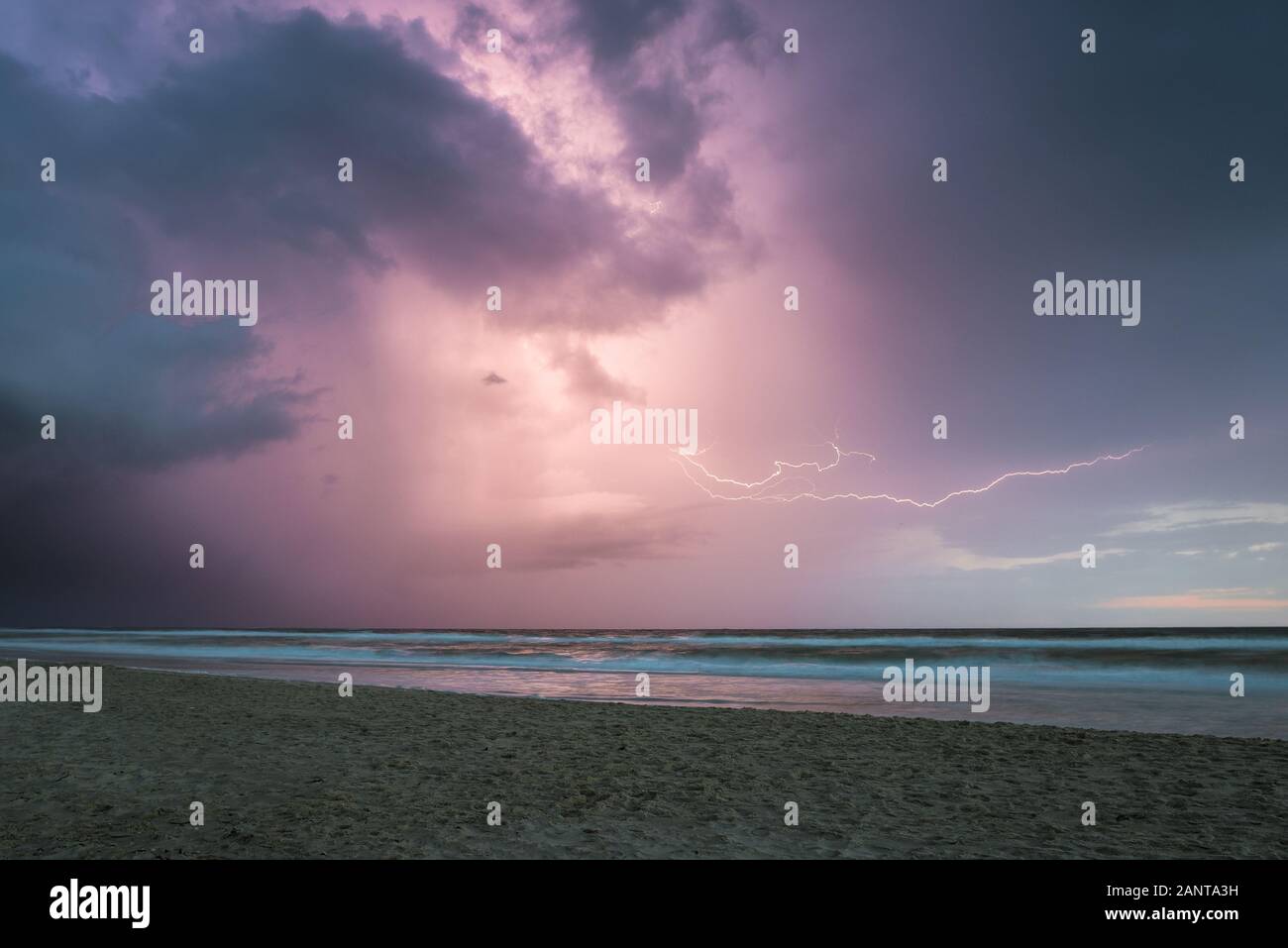 Elektrischer Sturm an der niederländischen Küste kurz nach Sonnenuntergang. Horizontale Blitzbolzen sind über dem Meer sichtbar. Stockfoto