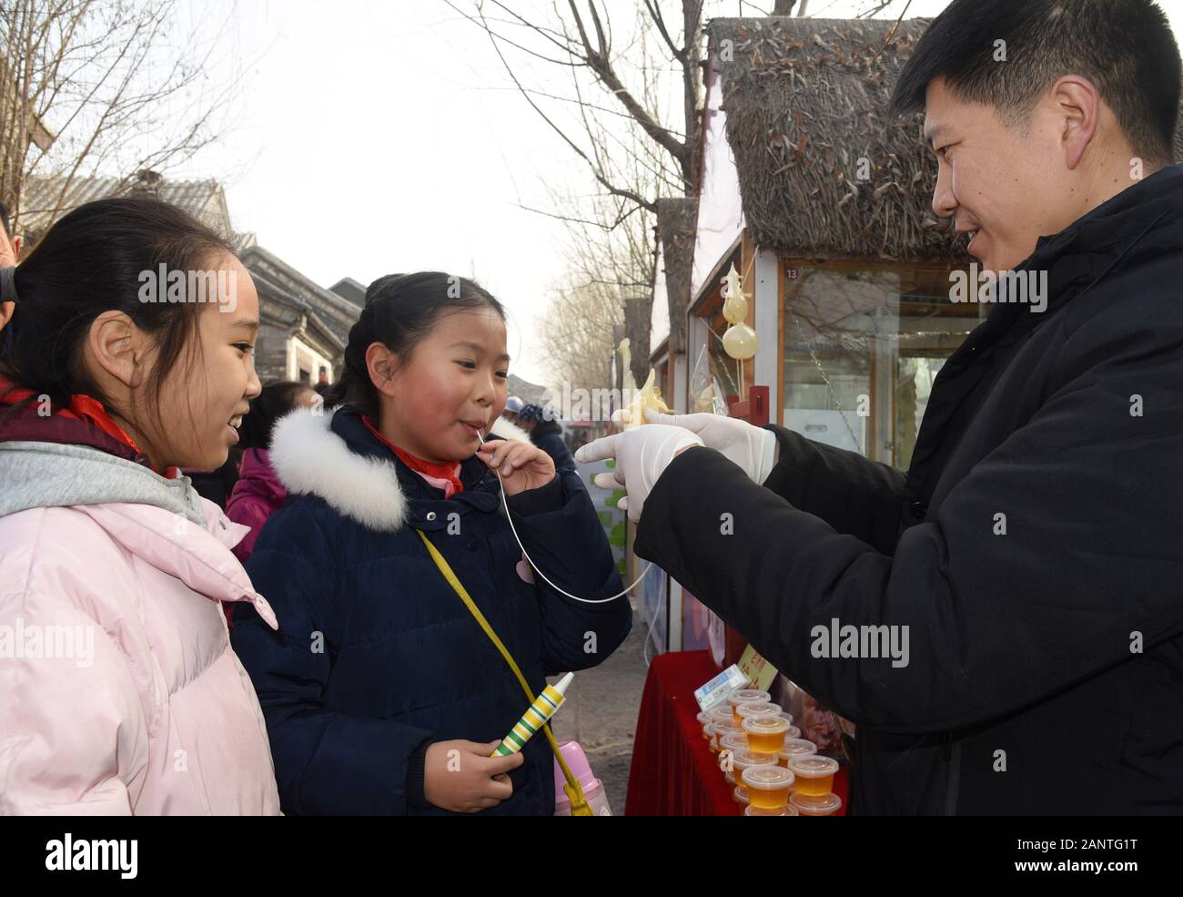 Jinan, Provinz Shandong in China. 19 Jan, 2020. Ein Mädchen versucht, Zucker - Abbildung blasen zu einem Frühlingsfest Markt themed auf immaterielle Kulturerbe an Baihuazhou historischen und kulturellen Block in Jinan abgehalten, Hauptstadt der ostchinesischen Provinz Shandong, Jan. 19, 2020. Credit: Wang Kai/Xinhua/Alamy leben Nachrichten Stockfoto