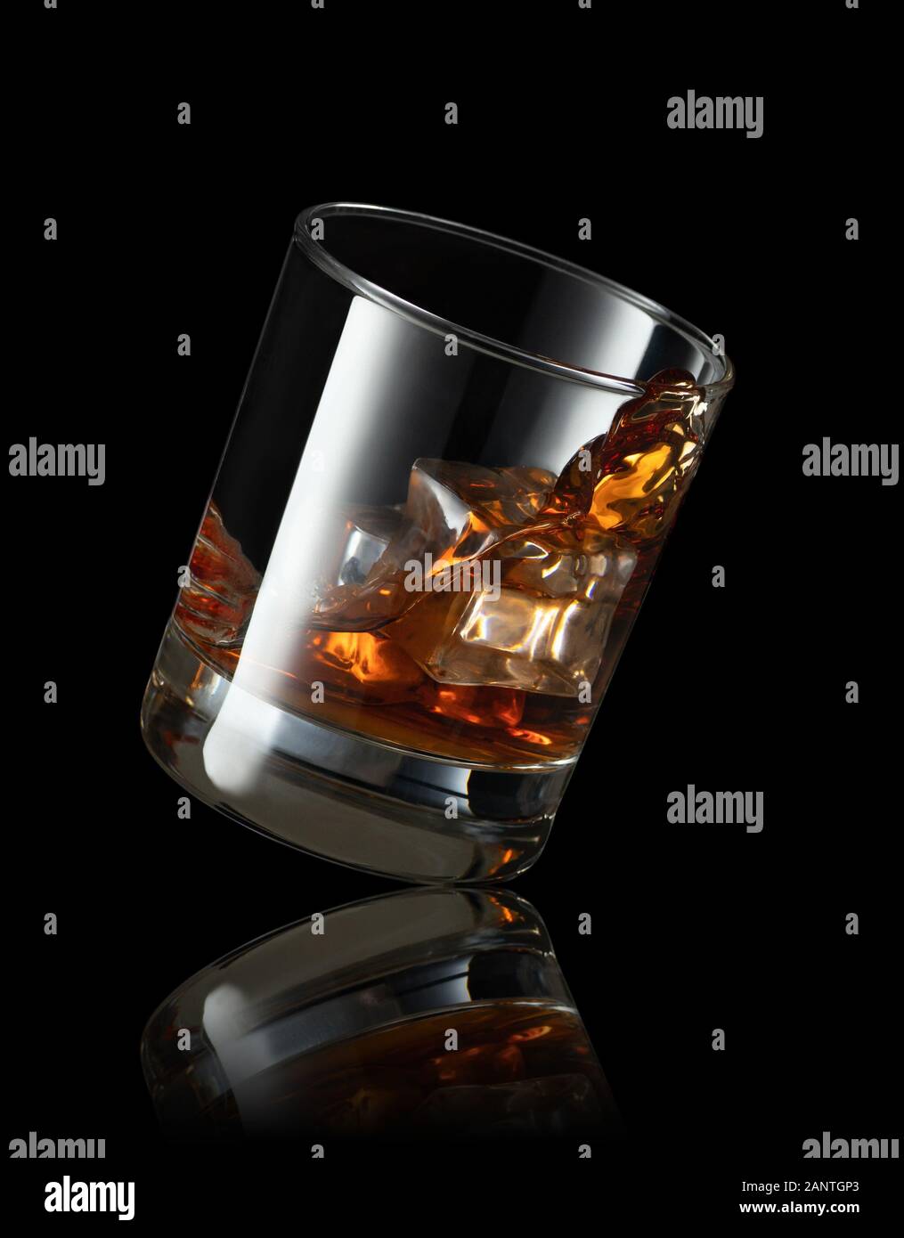 Fallende Glas Whisky mit Eiswürfel auf schwarzem Hintergrund Stockfoto