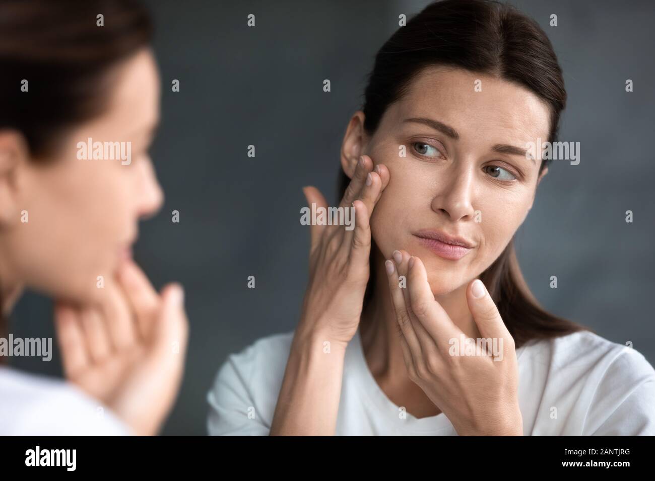 Close up unglückliche Frau bei Akne Flecken im Spiegel zu betrachten Stockfoto