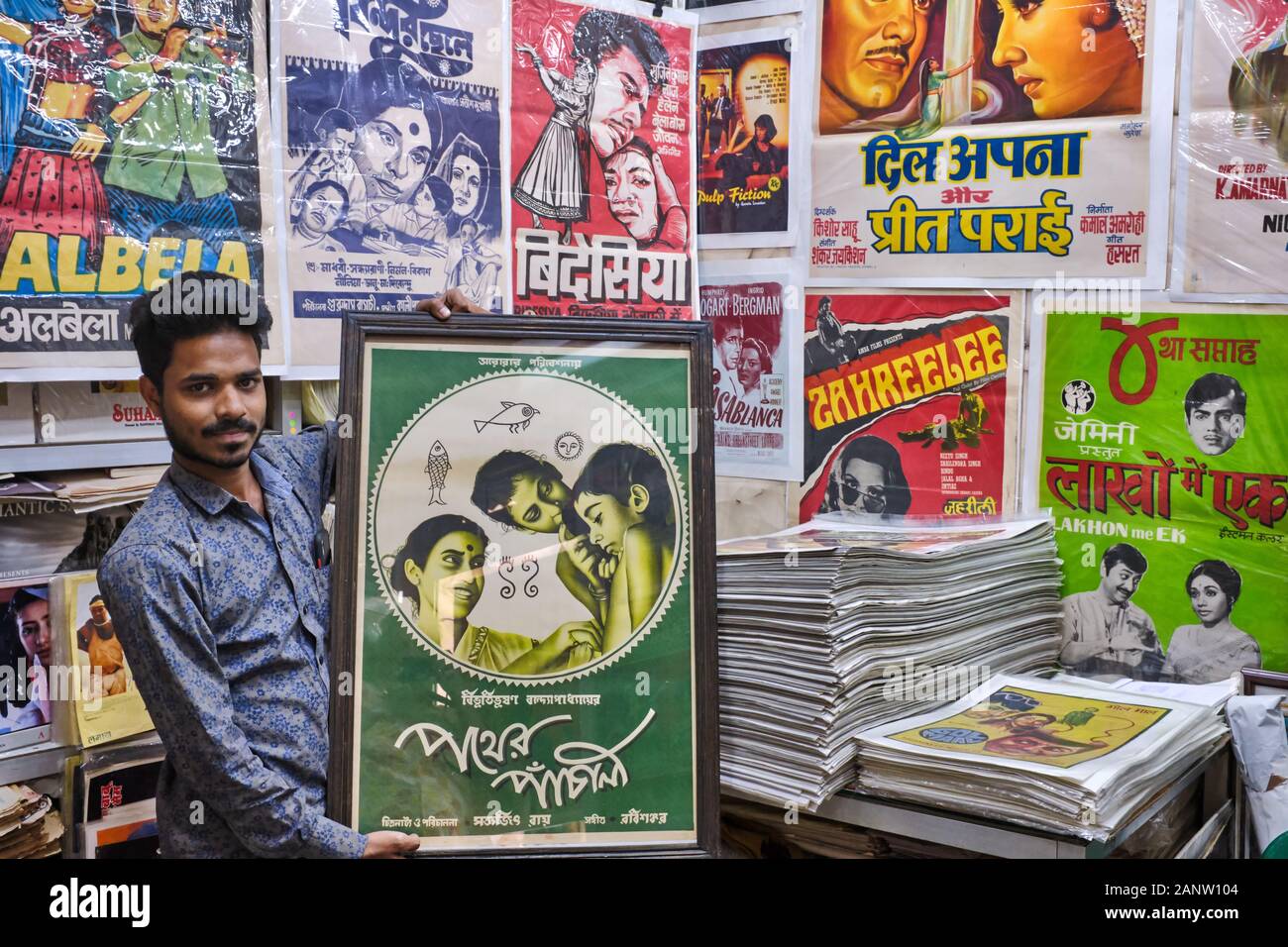 Kaleem Khan, ein Miteigentümer von Shop Poster Stuff in Chor Bazar (Diebemarkt), Mumbai, Indien, hält ein Originalposter des Films Pather Panchali Stockfoto