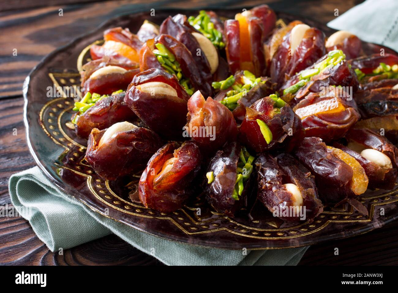 Getrocknete Datteln gefüllt mit kandierten Früchten und Nüssen auf einem rustikalen Holztisch. Stockfoto