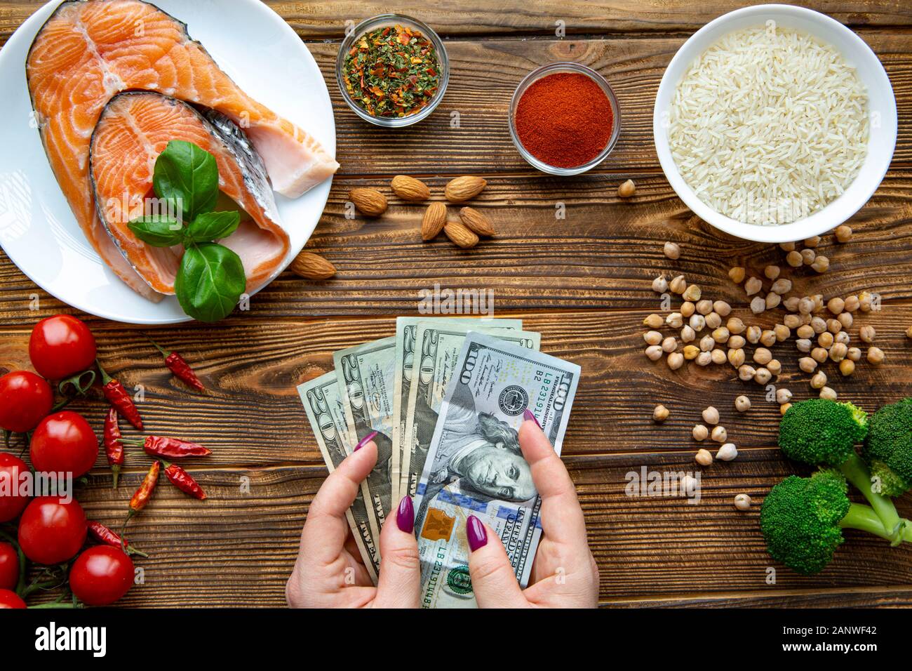 Hohe Kosten für gesundes Essen. Dollar Währung wert. Die finanzielle Situation in den USA. Lachs mit Reis, Gemüse und Bohnen. Stockfoto