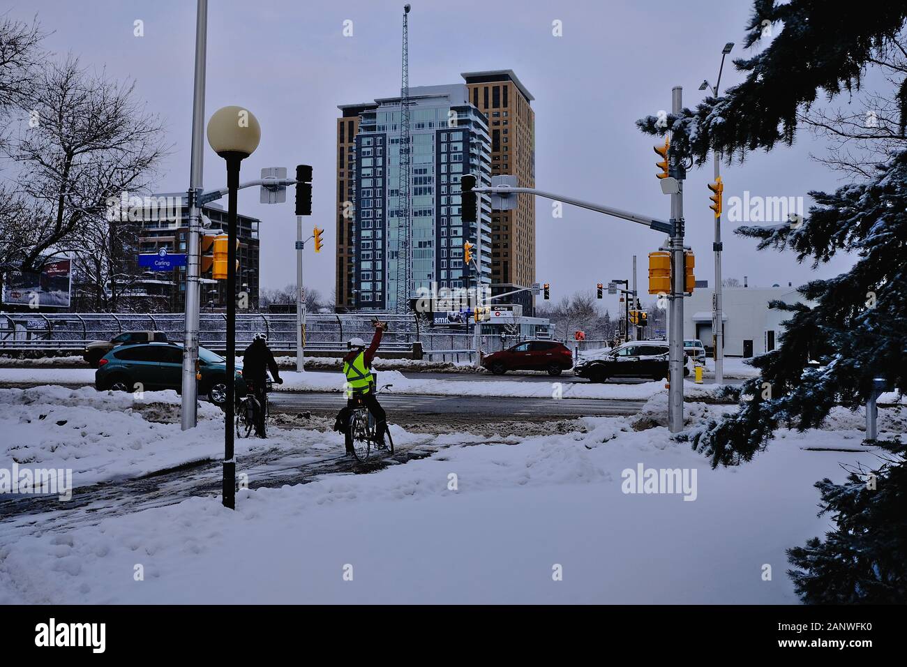 Winterradfahrer auf dem Trillium-Radweg warten an der Carling Street auf einen Lichtwechsel. Ottawa, Ontario, Kanada. Stockfoto