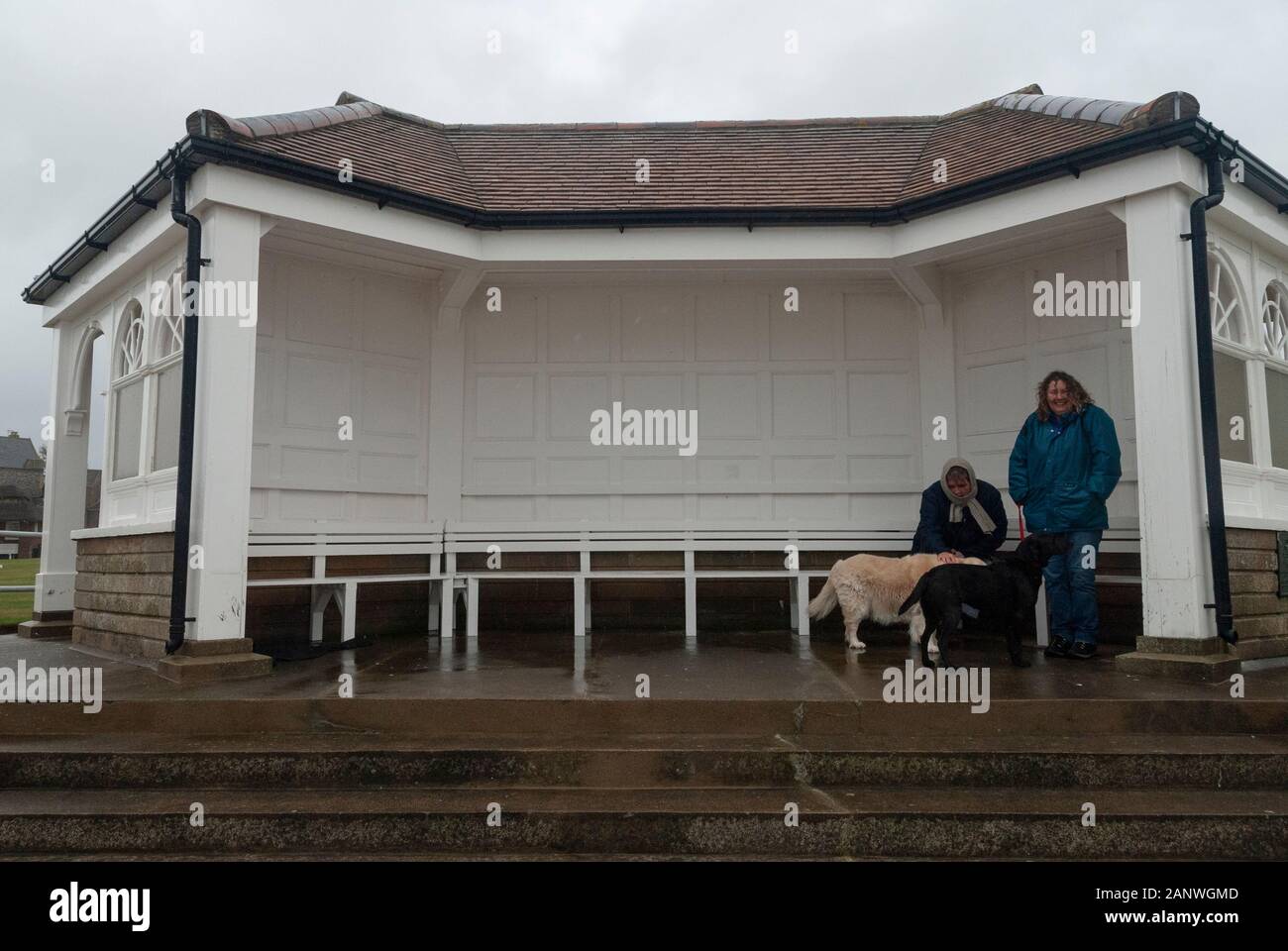 CROMER, Großbritannien - 13 Okt 2013 - Leute versuchen Tierheim aus dem regnerischen Wetter in Cromer Norfolk England Großbritannien zu nehmen Stockfoto