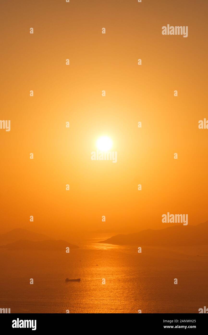 Tanker Schiff auf dem Ozean Horizont mit Sonnenuntergang Himmel und Küste Hintergrund Stockfoto