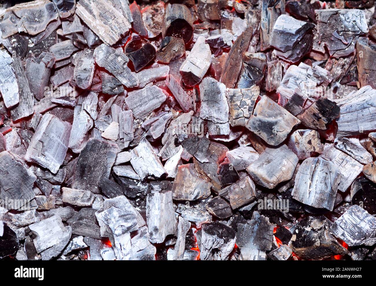 Kohle brennen. Glühende Glut. Feuerstelle mit glühender Kohle. Live-Kohleverbrennung. Hintergrund. Nahaufnahme. Stockfoto