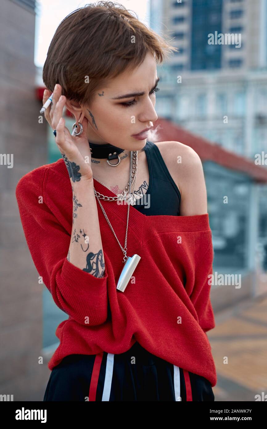 Urban Style. Junge stilvolle Frau, die draußen rauchen Zigarette nachdenklich close-up Stockfoto