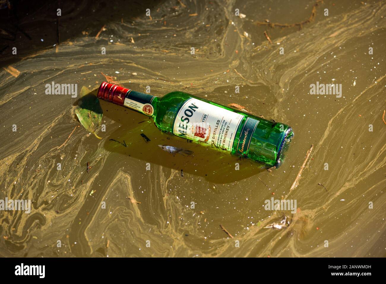 Leere Whiskey-Flasche im Kanal. Stockfoto