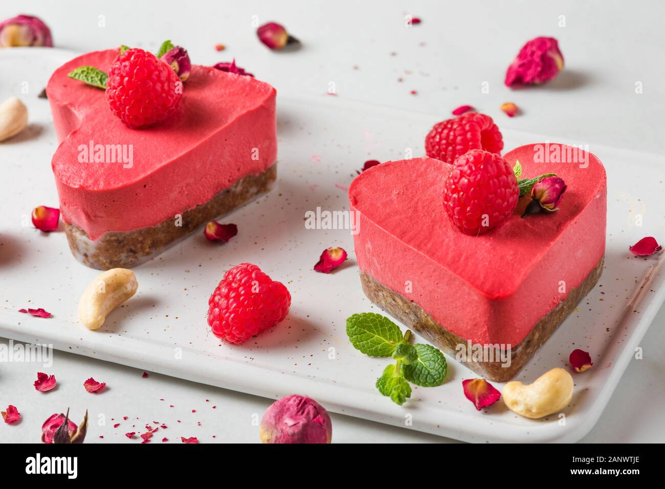 In Herzform rot raw vegan Kuchen mit frischen Himbeeren, Minze und getrockneten Blumen. Valentines Tag Dessert. Gesunde leckeres Essen. in der Nähe. Liebe anhand von quantitativen Simulatio Stockfoto