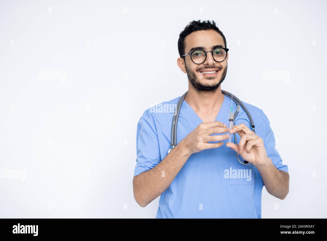 Glückliche junge männliche Kliniker mit toothy Lächeln, Injektion zu machen Stockfoto