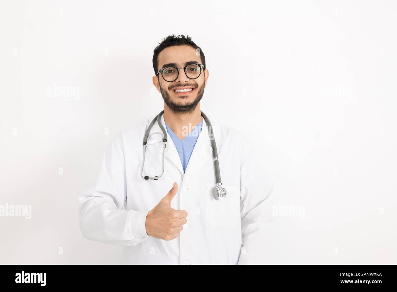 Junge lächelnde Klinikpersonal in Brillen und Jungtieren mit Daumen hoch Stockfoto