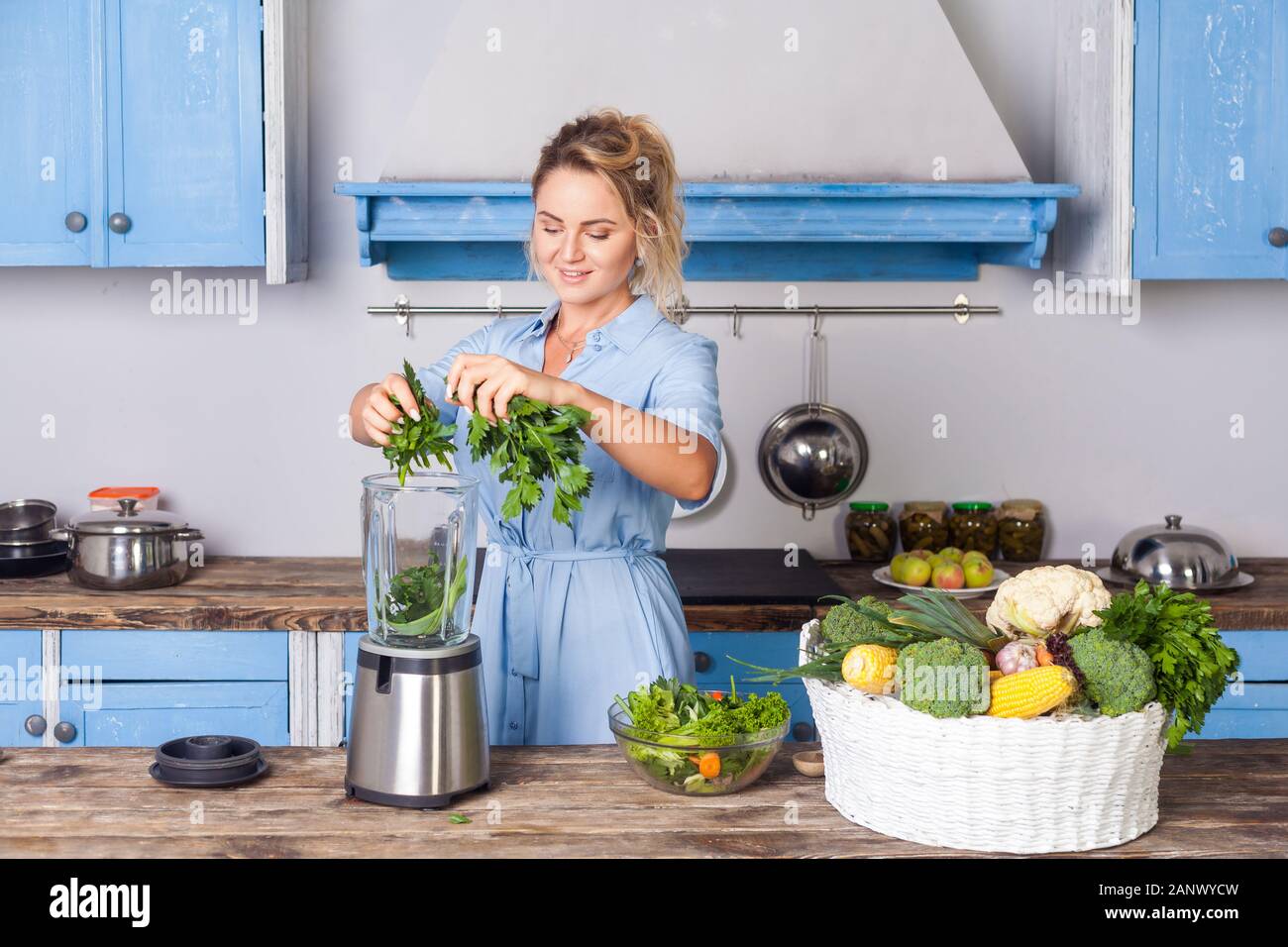 Glückliche Frau Zutaten in Blender gesunden Smoothie zum Frühstück zu machen, kochen Gemüse Zubereitung Salat in der modernen Küche, Rohkost di Stockfoto