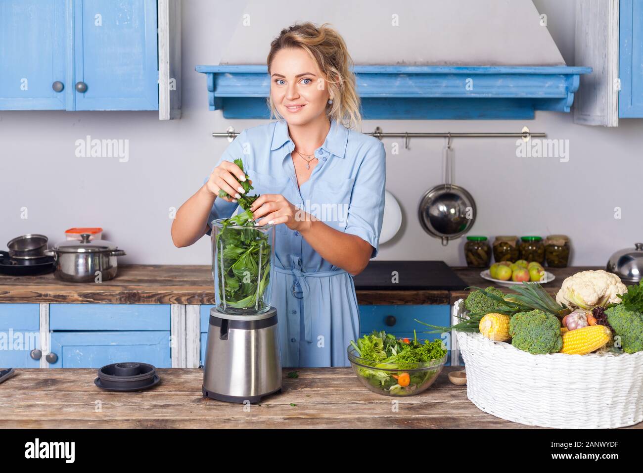 Glückliche Frau Zutaten in Blender gesunden Smoothie zum Frühstück zu machen, kochen Gemüse Zubereitung Salat in der modernen Küche, Rohkost di Stockfoto