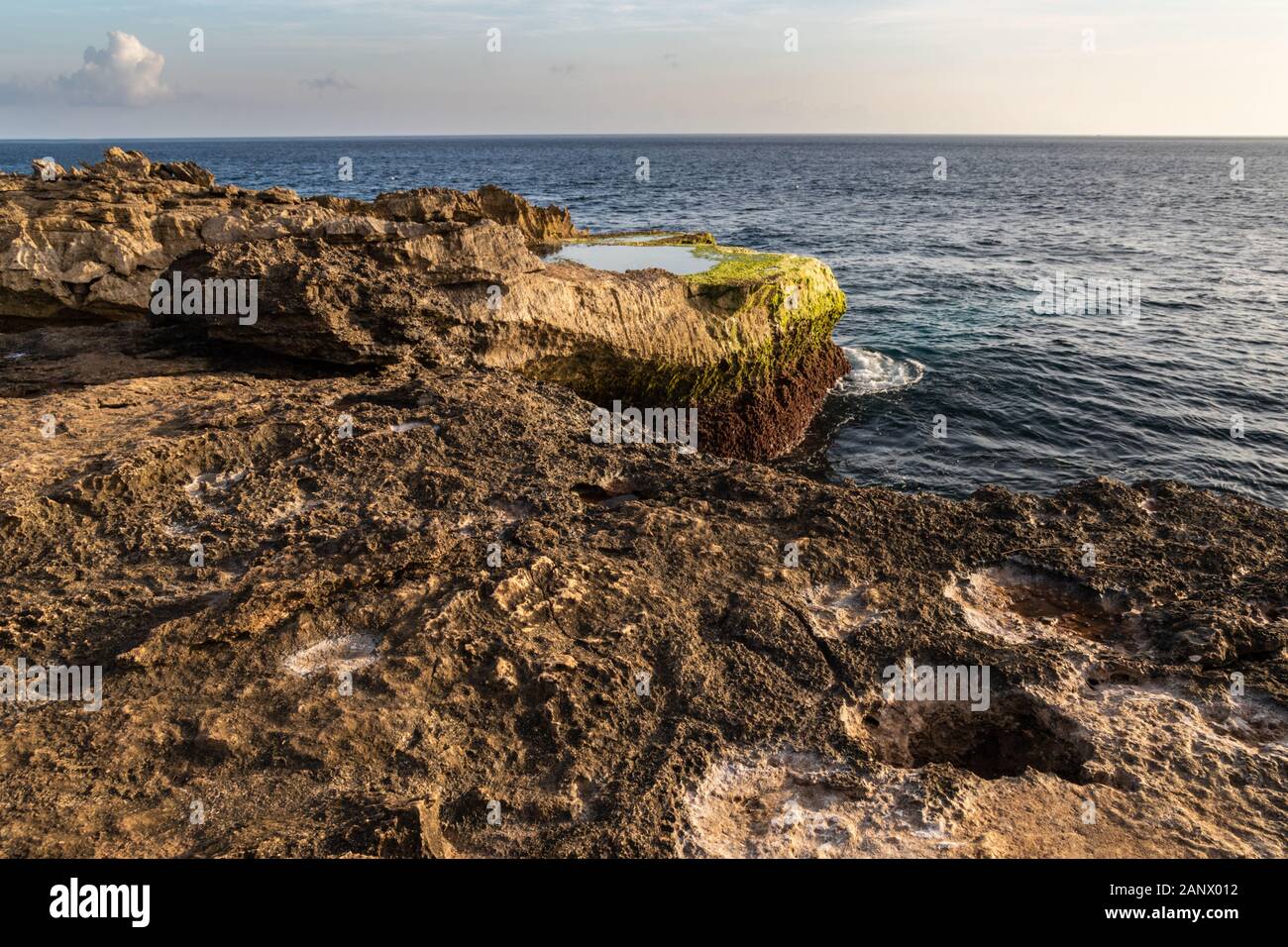 Felsenküste bei Devil's Träne auf der Insel Nusa Lembongan, Bali, Indonesien. Felsigen Ufer mit gezeitentümpel im Vordergrund. Küste, Meer, Himmel & Wolken. Stockfoto