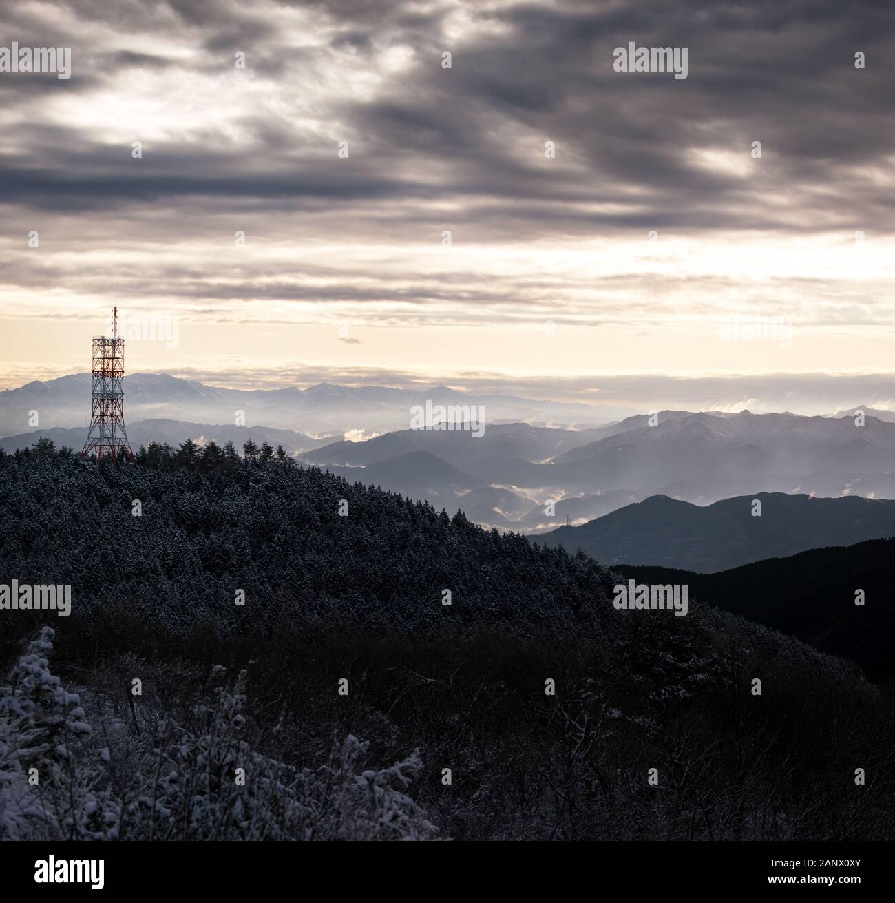 Kommunikation Turm auf schneebedeckten Berg mit Blick auf nebligen Tal bei Sonnenaufgang Stockfoto