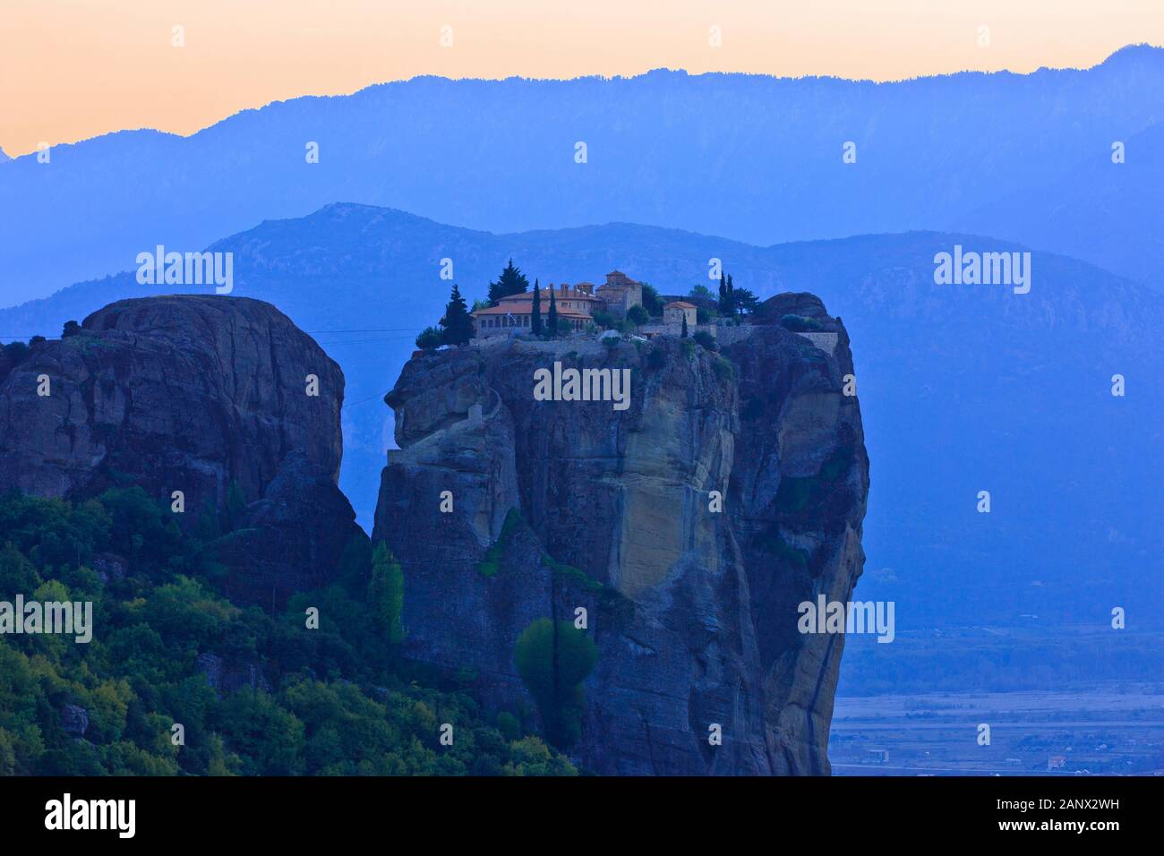 Panoramablick über das Kloster der Heiligen Dreifaltigkeit - Agia Triada (1476) in der Abenddämmerung in Meteora, Griechenland Stockfoto