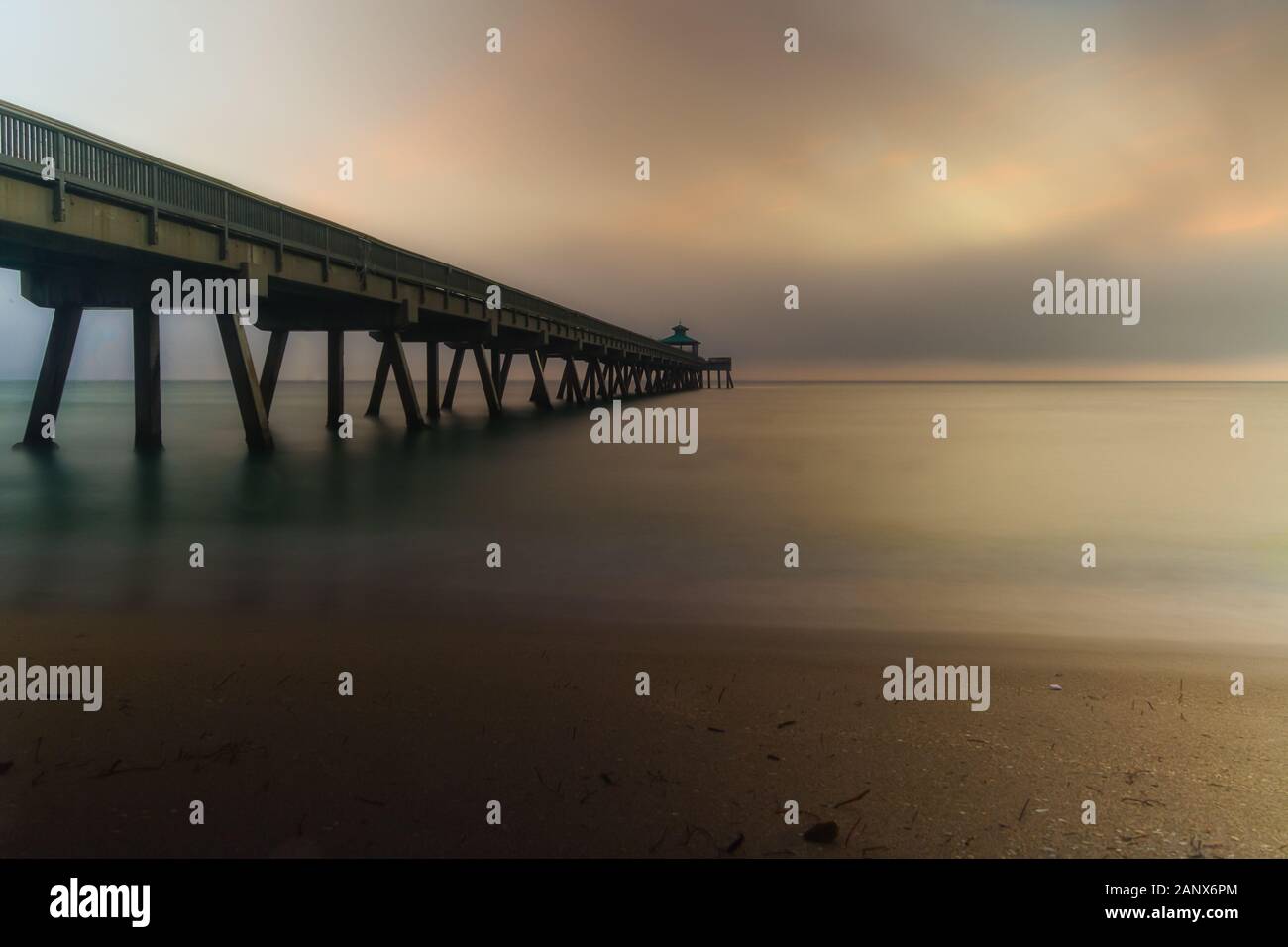 Lange Exposition eines Foggy Sonnenaufgangs am Deerfield Beach Fishing Pier Stockfoto