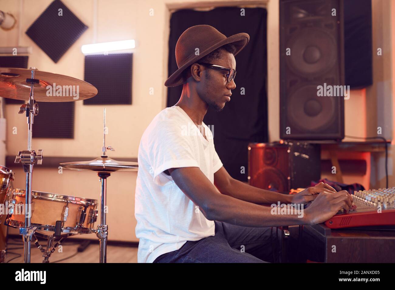 Seitenansicht Porträt der jungen Afrikaner Mann schreiben Musik im Tonstudio mit Ton equalizing Mixer, Kopie Raum Stockfoto