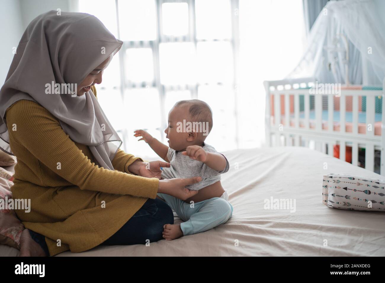 Asiatische muslimen wechseln ihre Kleidung für Babyjungen Stockfoto