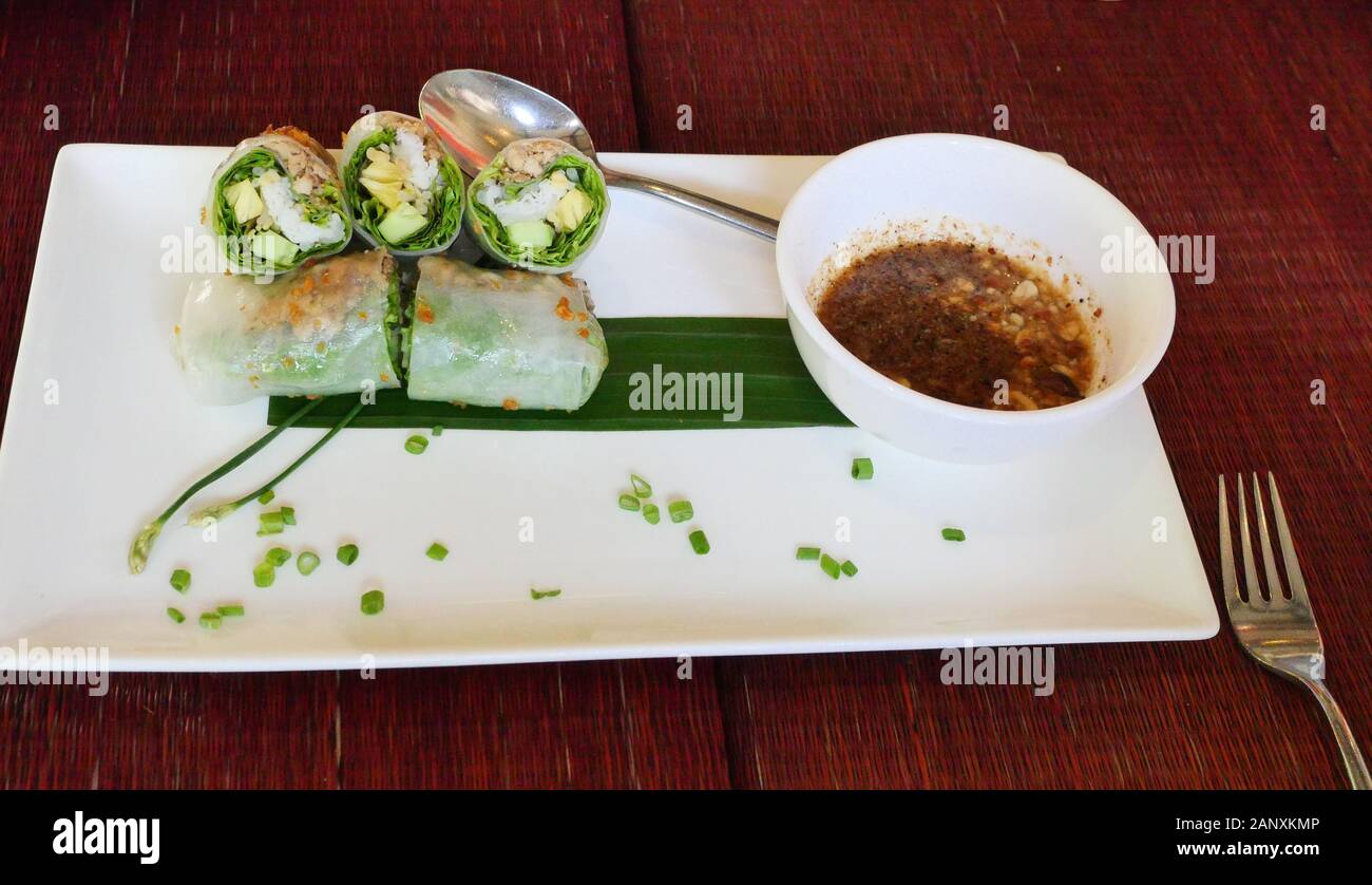 Gemüse Nudeln (Pho Cuon) auf die weiße Platte mit Soße auf dem roten Tisch gerollt, Vietnamesisch vegetarische und vegane Lebensmittel in Kambodscha Stockfoto