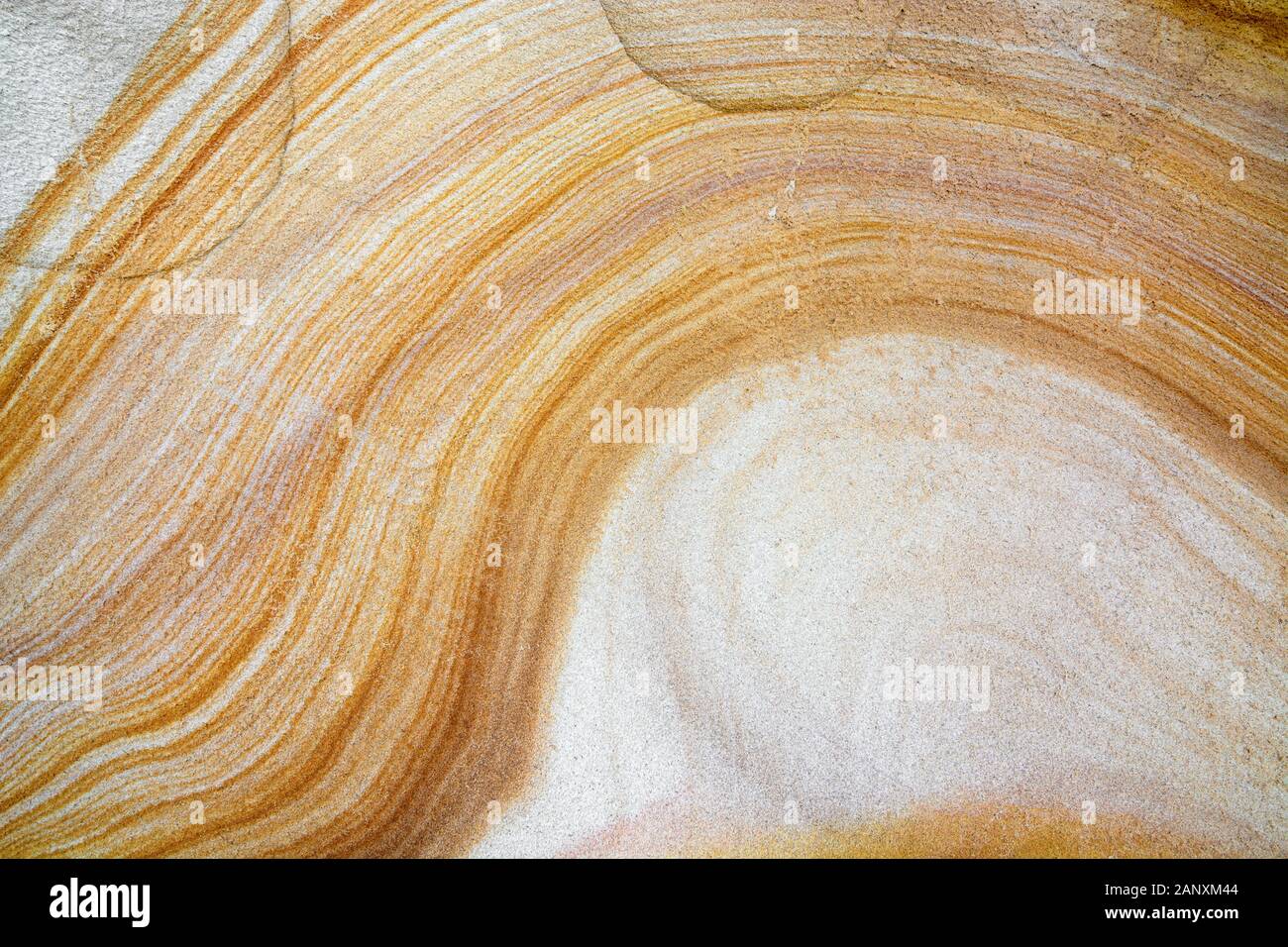 Nahaufnahme der natürlichen Sandsteinfruktur mit gelbem und weißem Wellenmuster Stockfoto