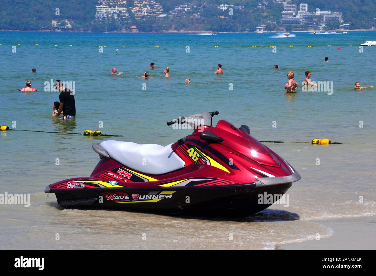 Ein Jetski und Leute genießen das Meer Wasser in einen sicheren Bereich, gekennzeichnet durch eine Floatanlage in Patong Beach, Phuket, Thailand, Asien, an einem heißen Tag Stockfoto