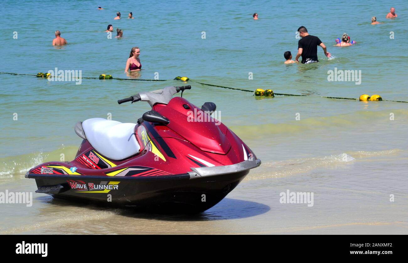 Ein Jetski und Leute genießen das Meer Wasser in einen sicheren Bereich, gekennzeichnet durch eine Floatanlage in Patong Beach, Phuket, Thailand, Asien, an einem heißen Tag Stockfoto