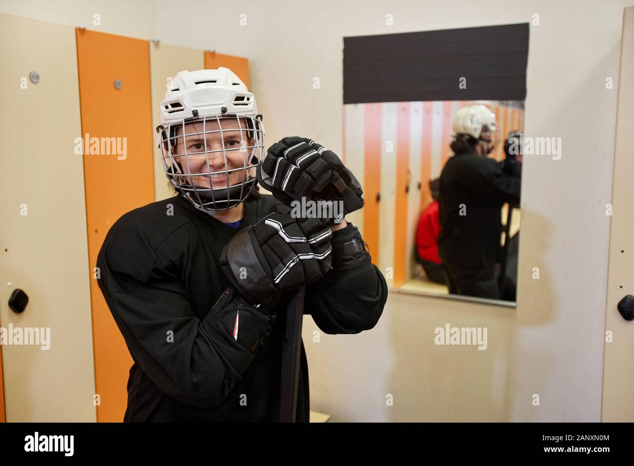 Taille bis Portrait von weiblichen hockey player lächelnd in die Kamera während im Schließfachraum Posing, kopieren Raum Stockfoto