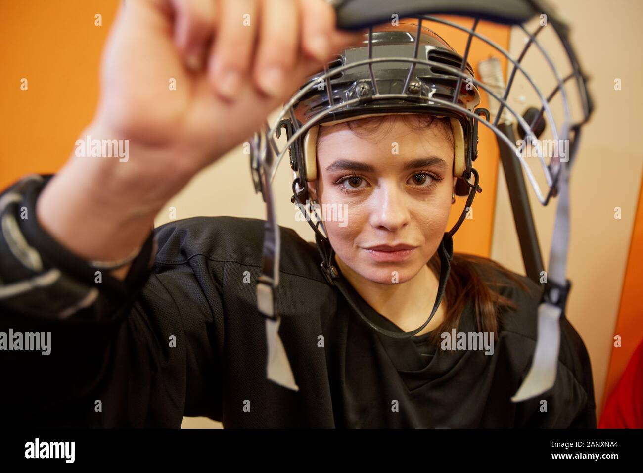 Nahaufnahme der weiblichen Hockey Player öffnen Gesichtsschutz und lächelnd an der Kamera in der Umkleidekabine, kopieren Raum Stockfoto