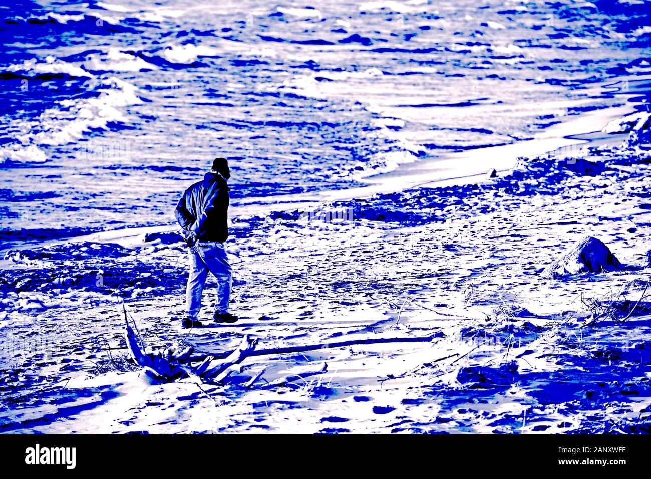 Ältere männliche Wandern der Sturm übersät Strand in der Nähe der Ludington State Park Beach House im Dezember in der Nähe von Ludington, Michigan, USA Ludington State Par Stockfoto