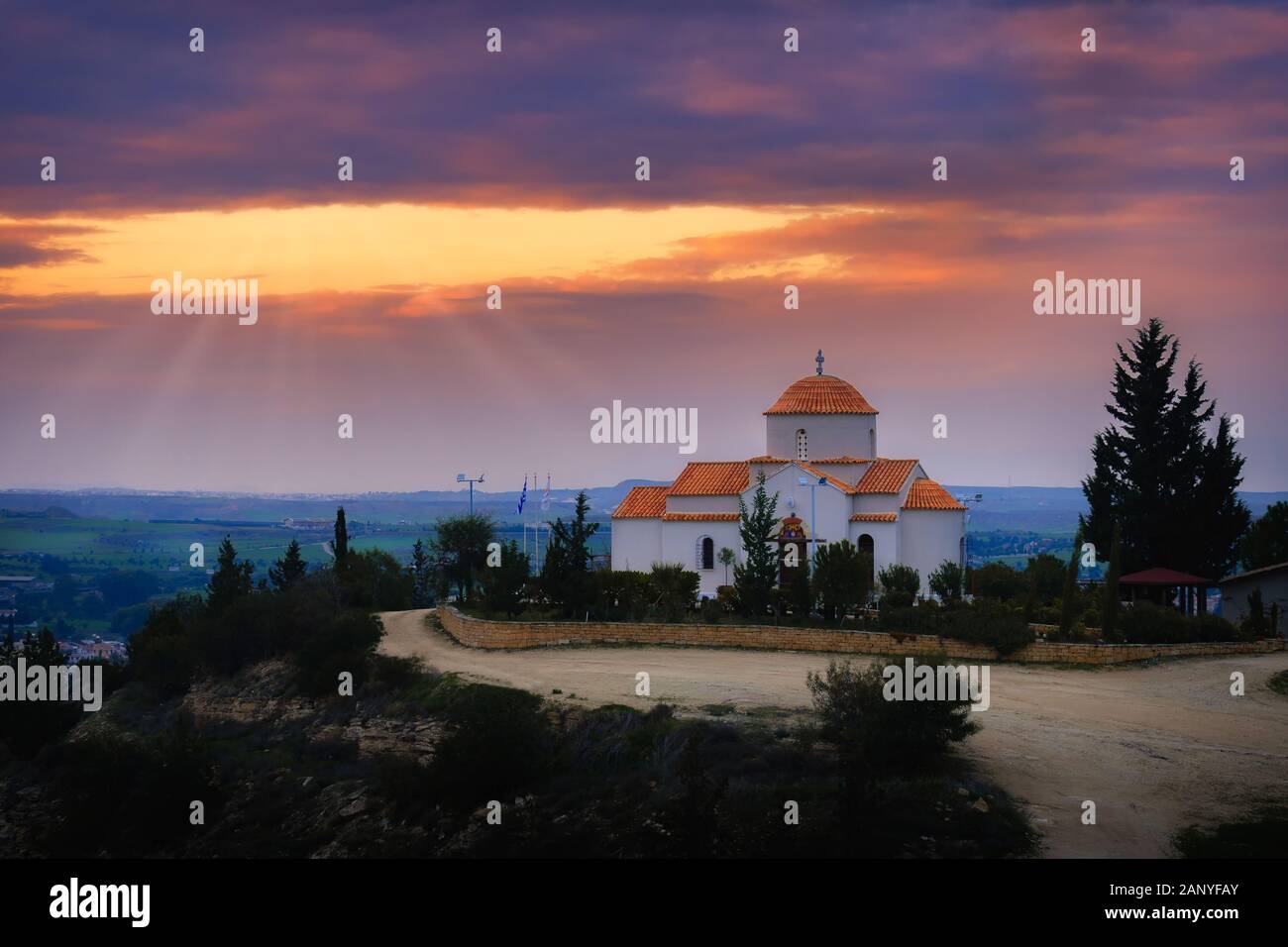 Panagia Tsampika orthodoxe Kirche auf einem Hügel im Bezirk Nikosia, Zypern bei Sonnenuntergang mit Lichtstrahlen Stockfoto