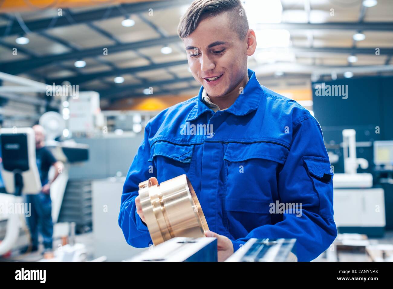 Lehrling in Metallbearbeitung bei Werkstück suchen Stockfoto