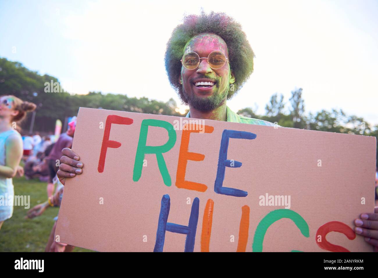 Afrikanischer Mann holding Banner 'Free Hugs' Music Festival Stockfoto
