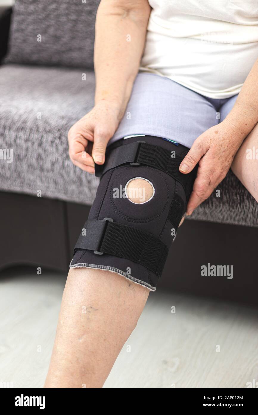 Person, die auf die schützende Knieorthese, Knie Support Stockfoto