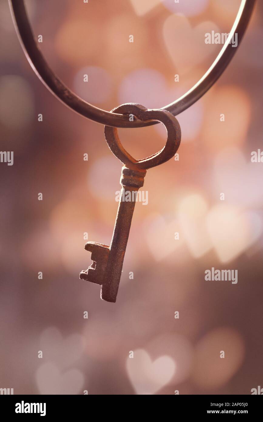 Alten rostigen Oldtimer Schlüssel in der Form eines Herzens, bokeh Hintergrund. Liebe und Valentinstag Grußkarte Stockfoto