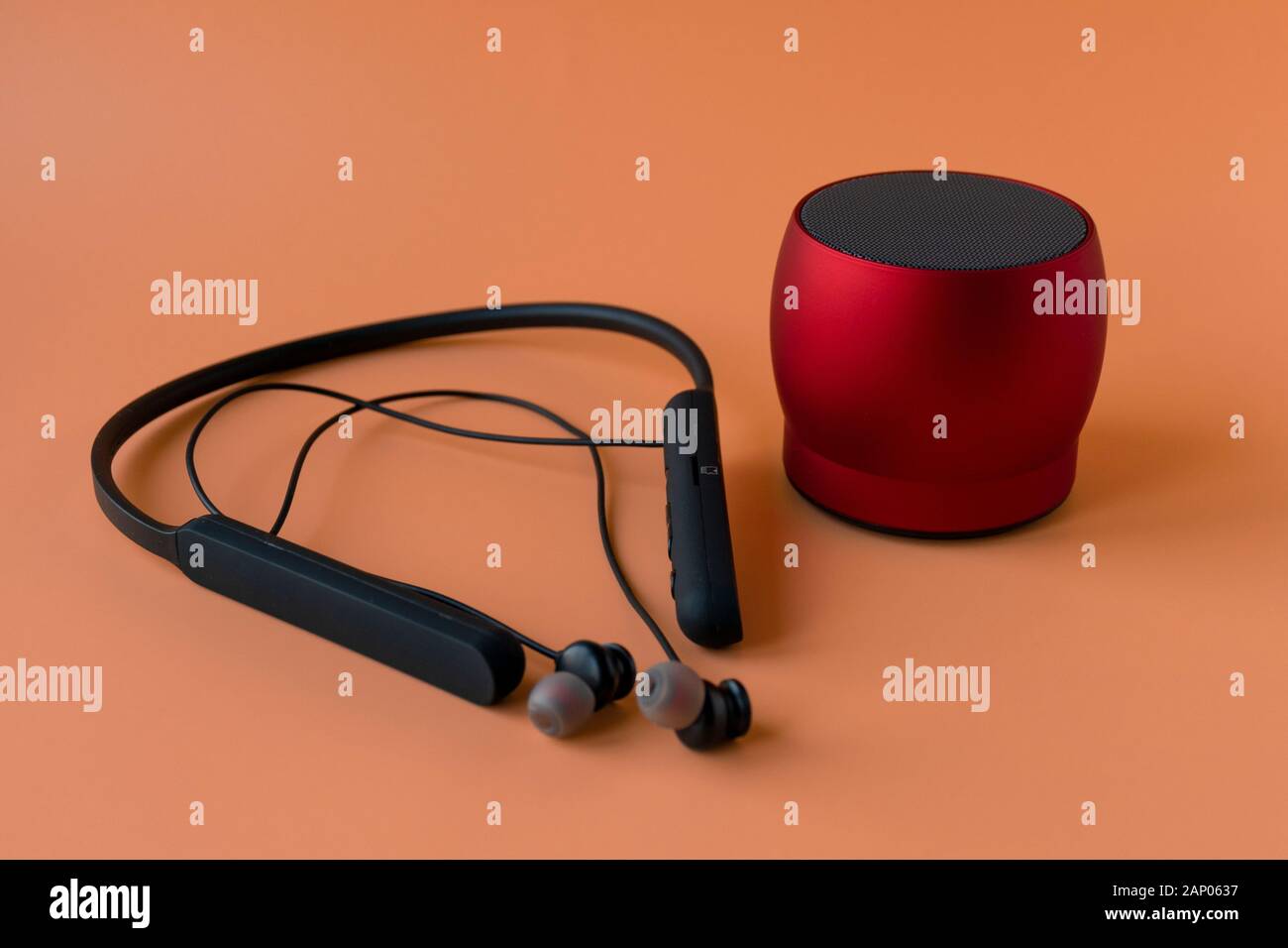 Drahtlose bluetooth-geräte für das Telefon, schwarze Kopfhörer und einen roten Lautsprecher. Headset für Telefon Stockfoto