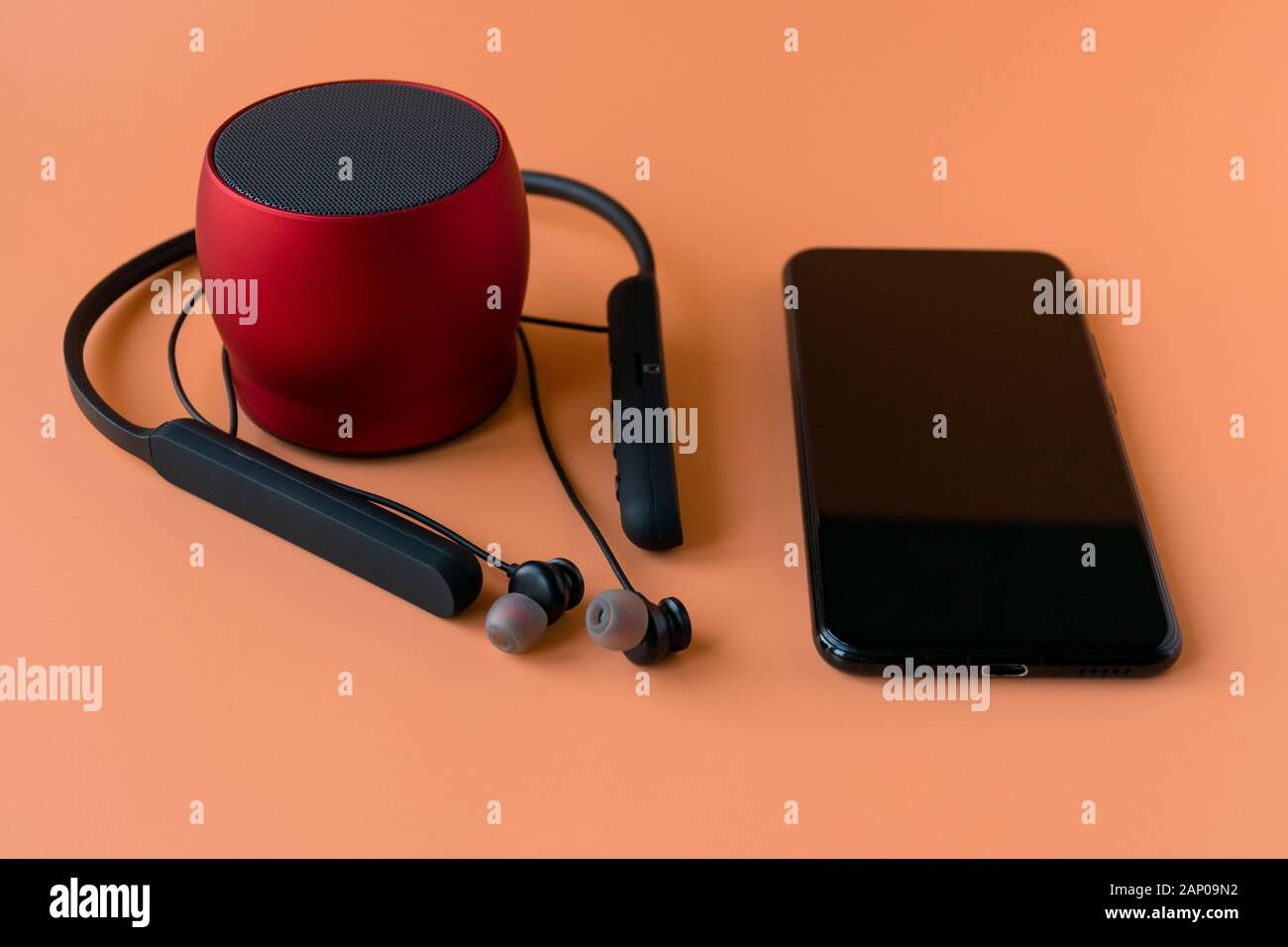 Drahtlose Geräte für das Telefon, schwarze Kopfhörer und einen roten Lautsprecher. Headset für Telefon Stockfoto