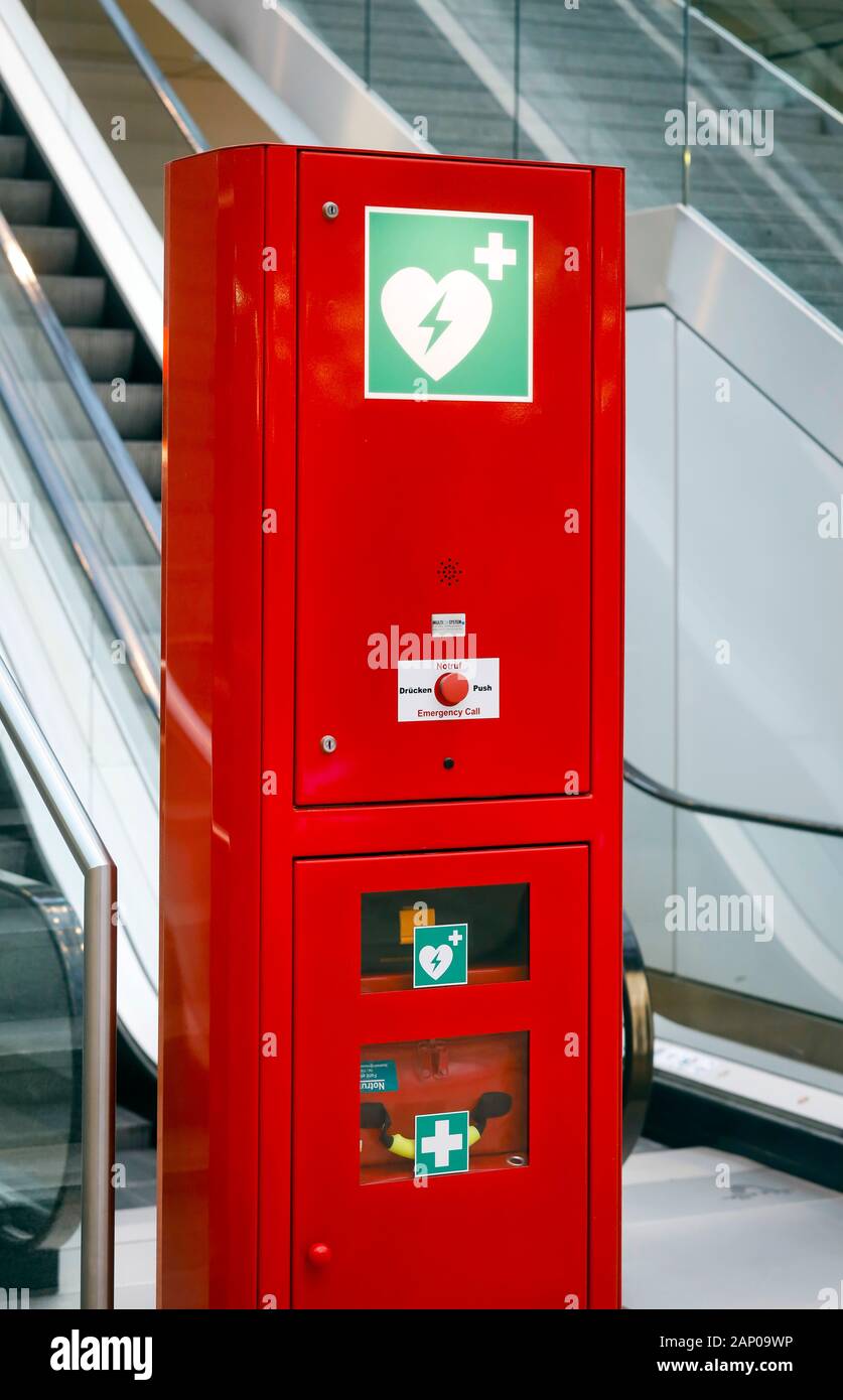Düsseldorf, Nordrhein-Westfalen, Deutschland - Rot Notruf Spalte mit Defibrillator und Erste Hilfe Kit im öffentlichen Raum, hier bei einer Rolltreppe Stockfoto
