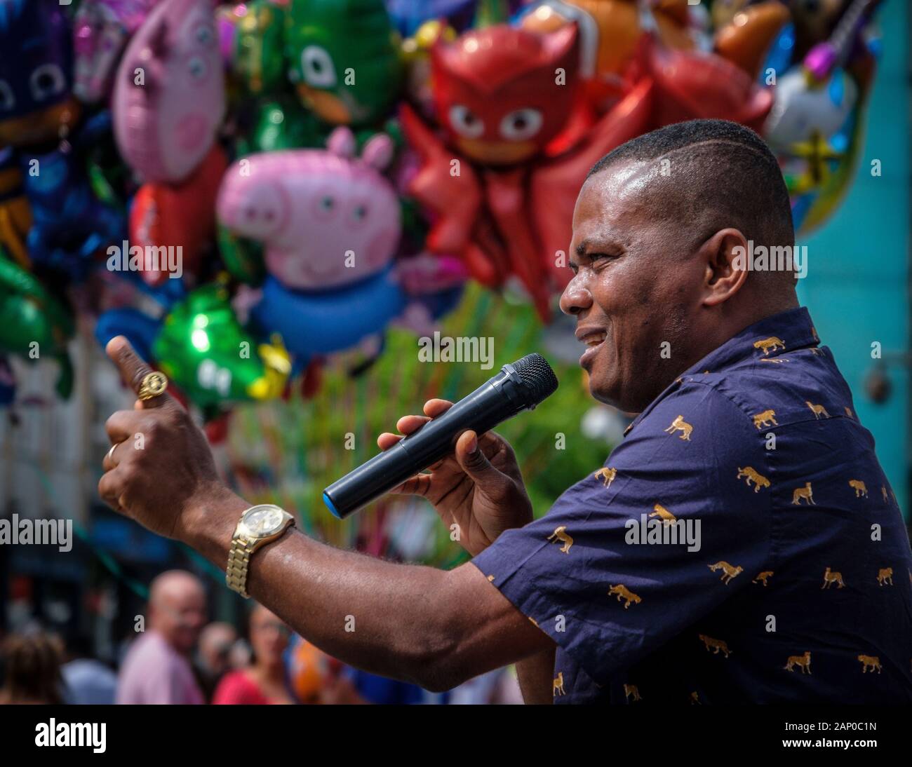 Mann, der Verkündigung des Wortes Gottes in einer Stadt mit einem Ballon der Teufel hinter sich. Stockfoto