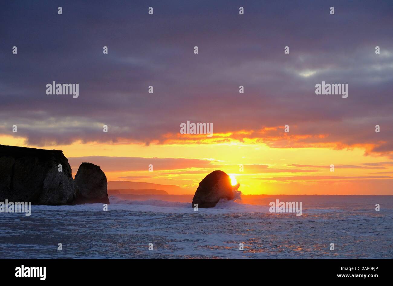 Am frühen Morgen Sonnenaufgang an der Freshwater Bay auf der Insel Wight an einem kalten Januar morgen mit einer rauhen Meer und Welle Absturz auf Rock Stockfoto