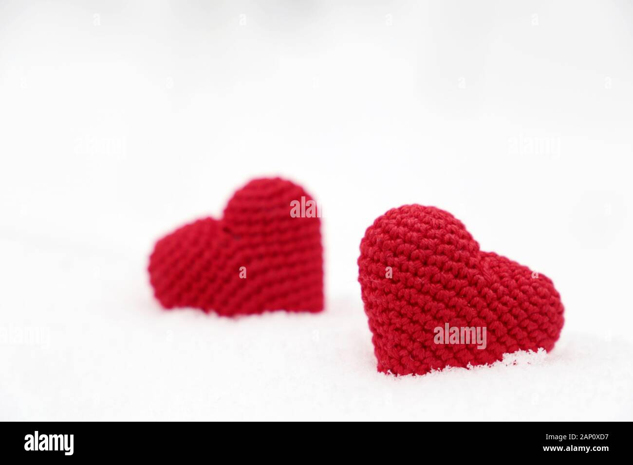 Liebe Herz, Valentinstag Karte, zwei Rote gestrickt Symbole der Leidenschaft in der Snow Drift. Hintergrund für romantische Veranstaltung, Feier oder Winter Wetter Stockfoto