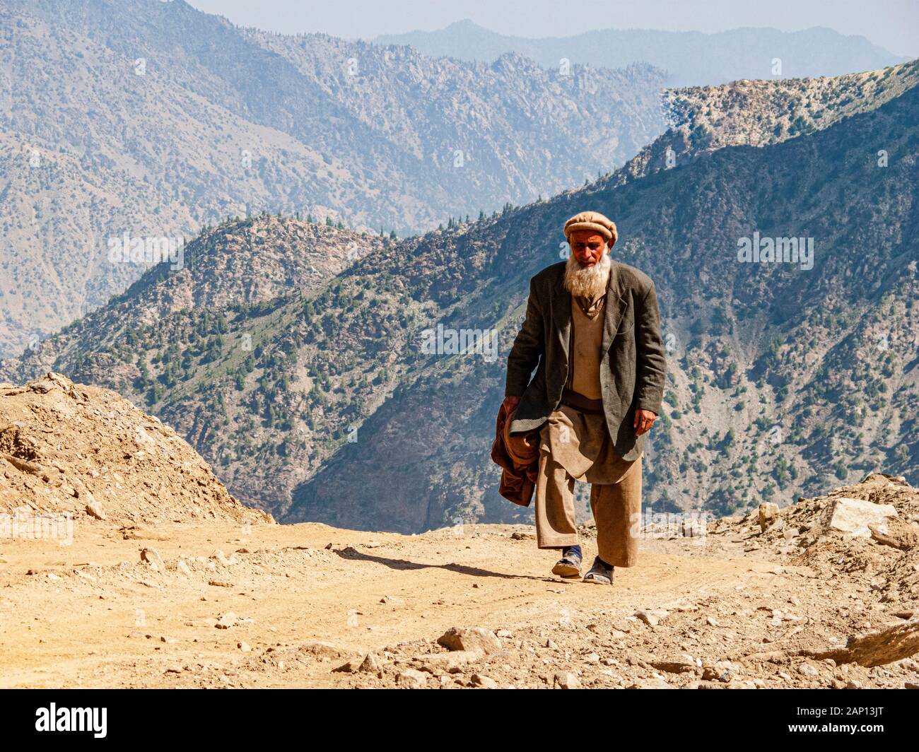 Mann vor Ort, der die staubige Straße zum Babusar-Pass hinauf geht Stockfoto