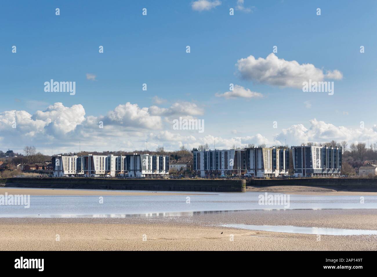 River Mersey bei Runcorn bei Ebbe. Direkt hinter dem Fluss befindet sich der Manchester Ship Canal und darüber hinaus die sechs Wohnblöcke der Decks. Stockfoto