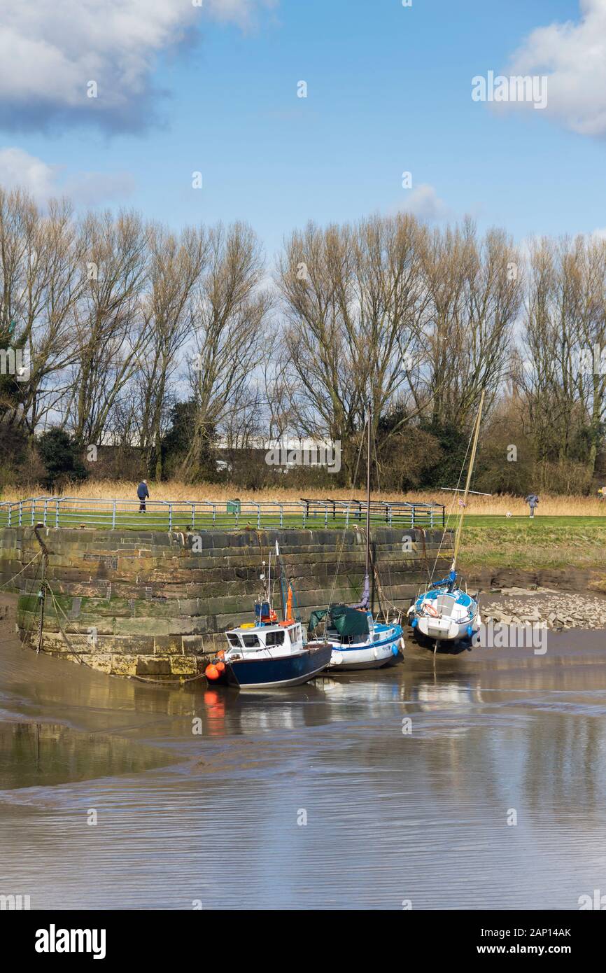 Kleine Boote moorierten bei Ebbe auf dem Fluss Mersey bei Widnes am Kai. Die Quayside befindet sich neben den Schleusen, die Mersey mit dem Kanal von St. Helen verbinden Stockfoto