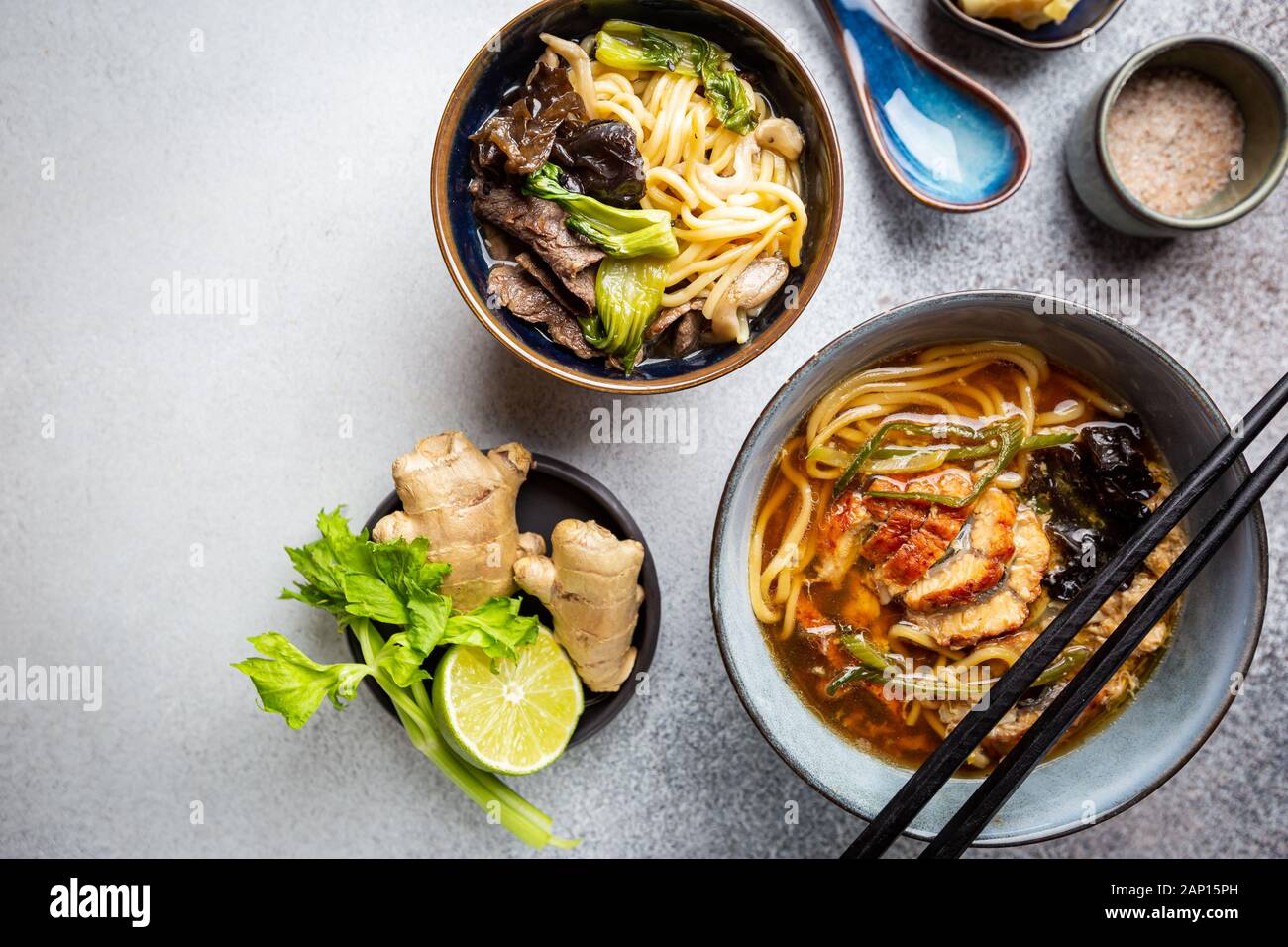 Satz serviert asiatische Suppen auf grauem Hintergrund der Ansicht von oben. Tom Yum Suppe, Aal Fischsuppe und Ramen Noodle Soup Stockfoto