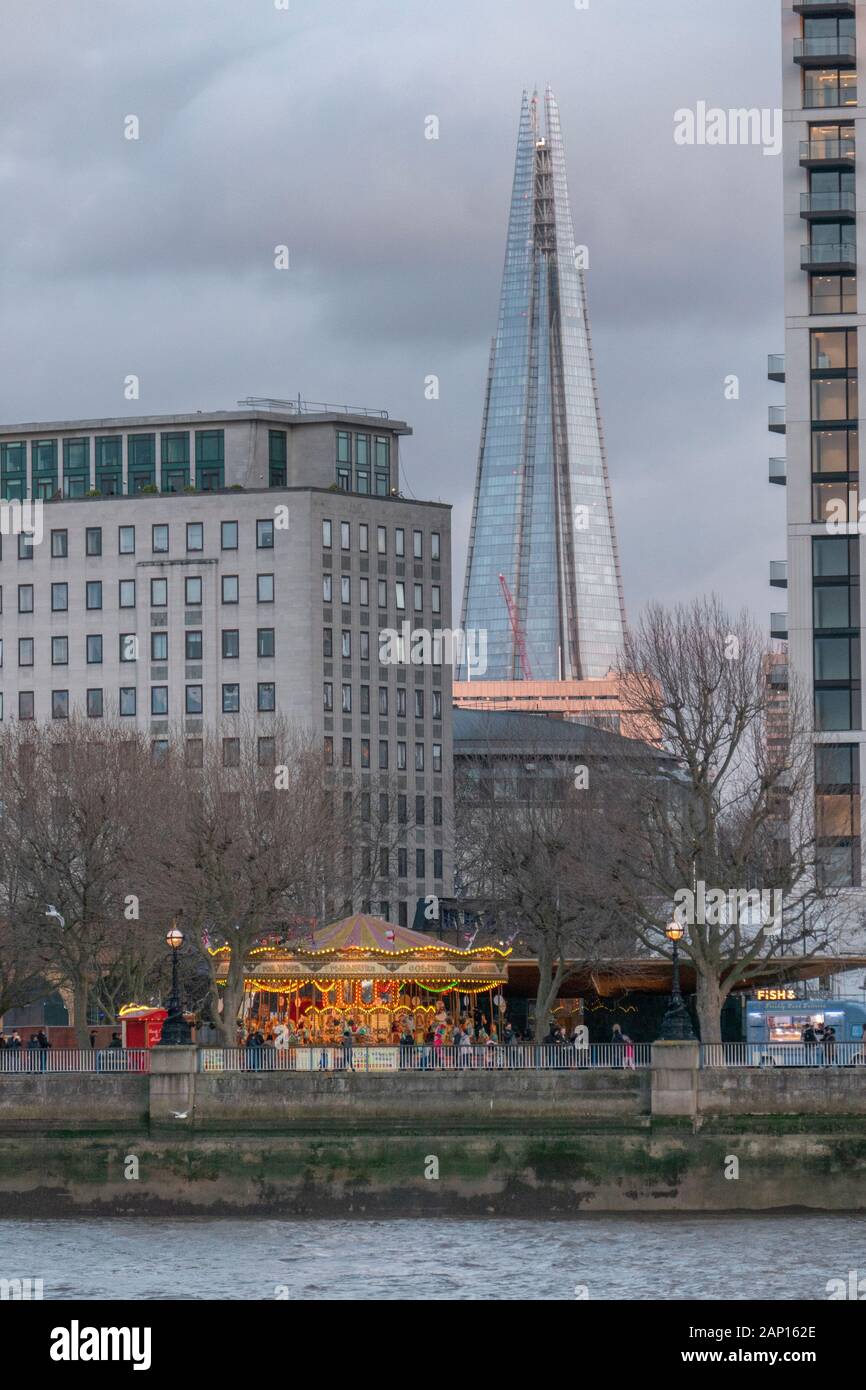 Ein buntes Karussell an der South Bank der Themse, Westminster und Der Shard Wolkenkratzer in London, England. Stockfoto