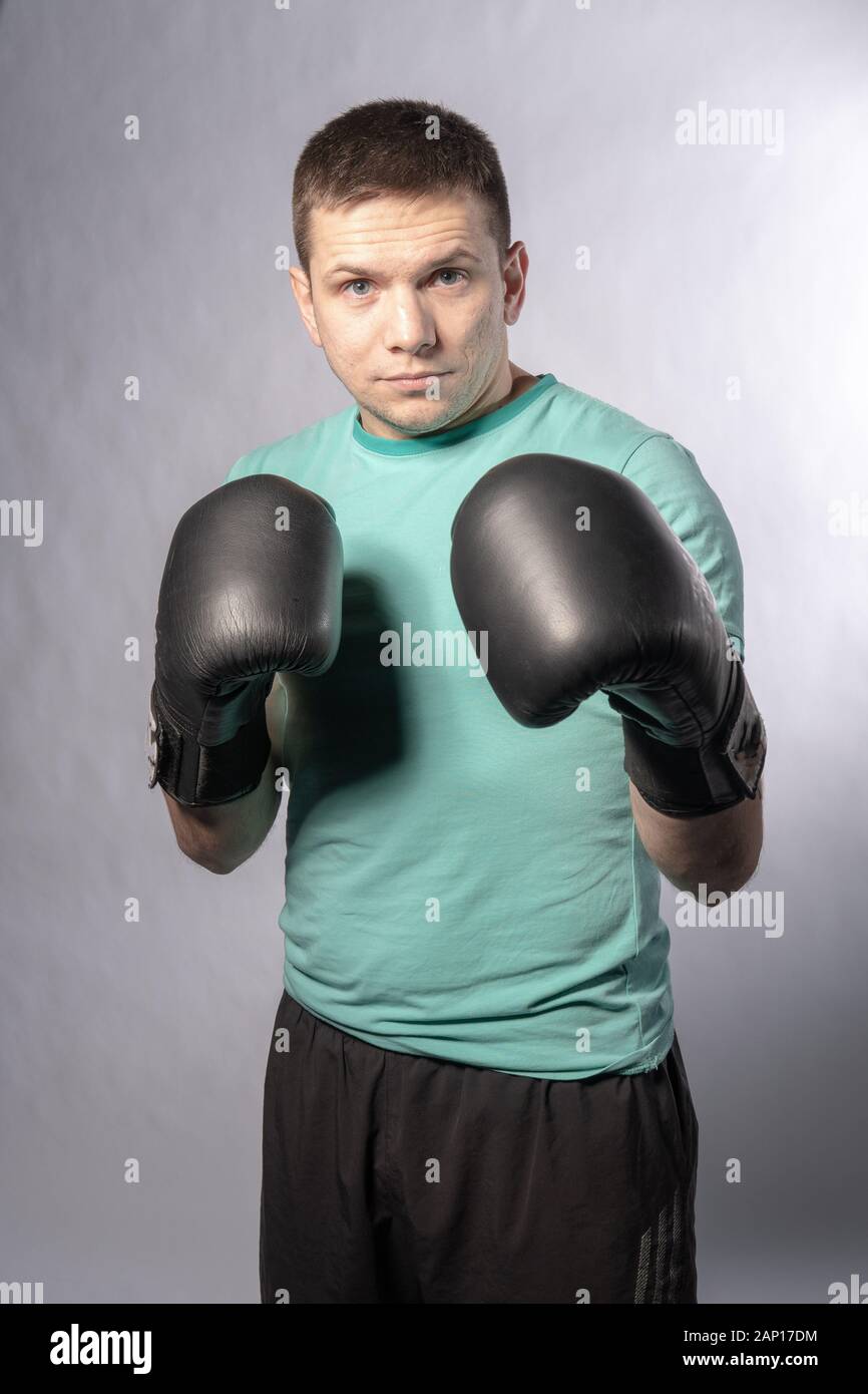 Boxer steht in schwarzen Handschuhen mit schwarzen Shorts verpönt Stockfoto