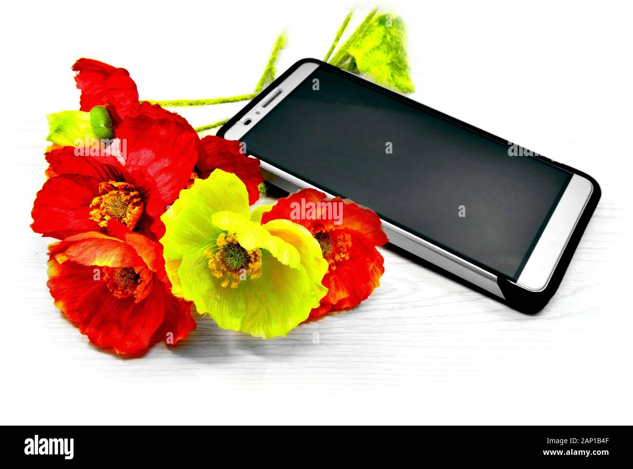 Smartphone und Kunstseide Blumen auf einem hellen Hintergrund. Stockfoto