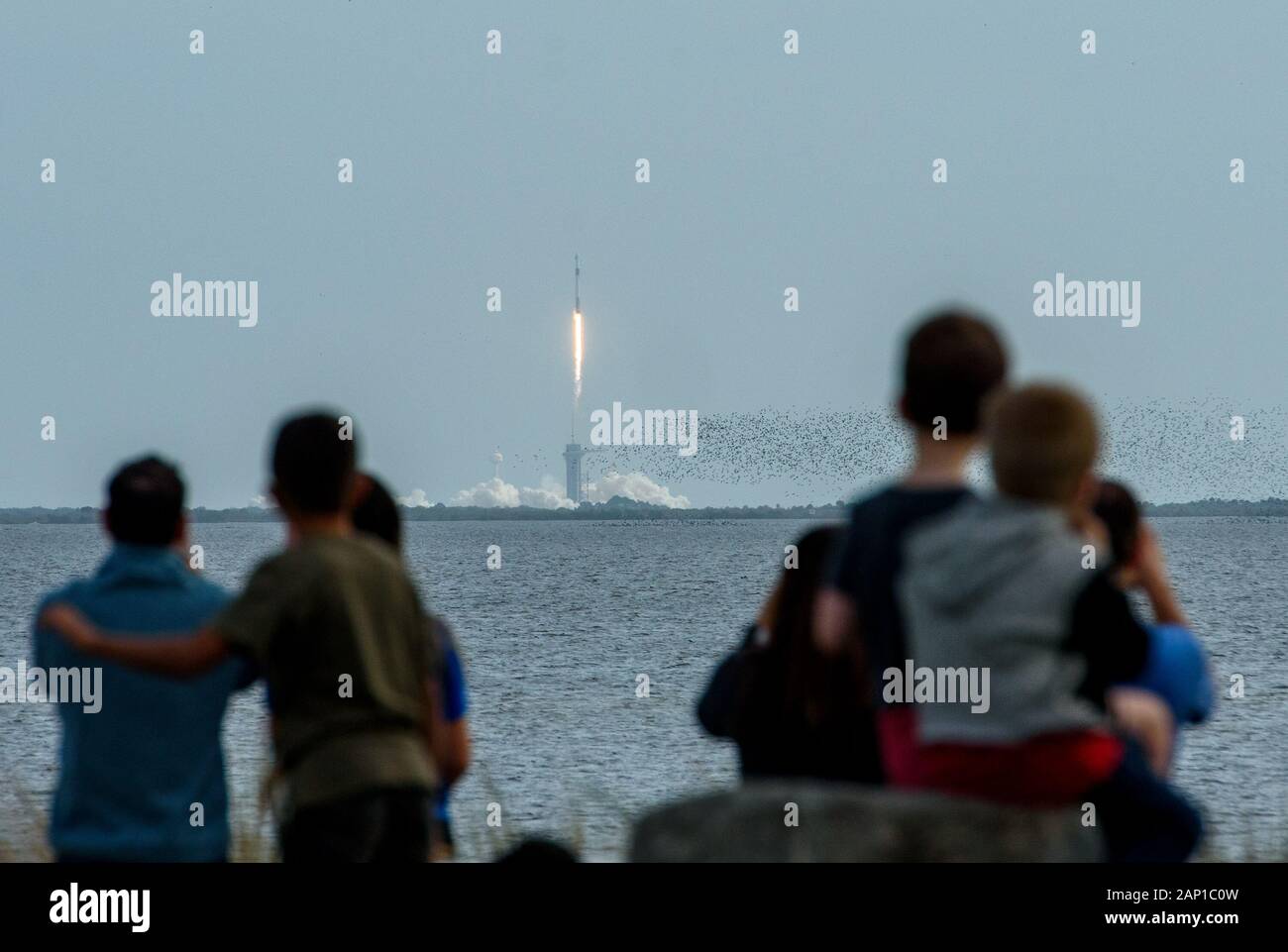 Die Menschen beobachten aus Titusville, Florida, wie eine SpaceX Falcon 9-Rakete, die die Astronautenkapsel Dragon der Crew mitführt, für einen Test in Cape Canaveral abhebt. Stockfoto